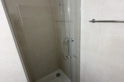 Paroi fixe sur profils chromés et porte de douche fermée avec joint magnétique