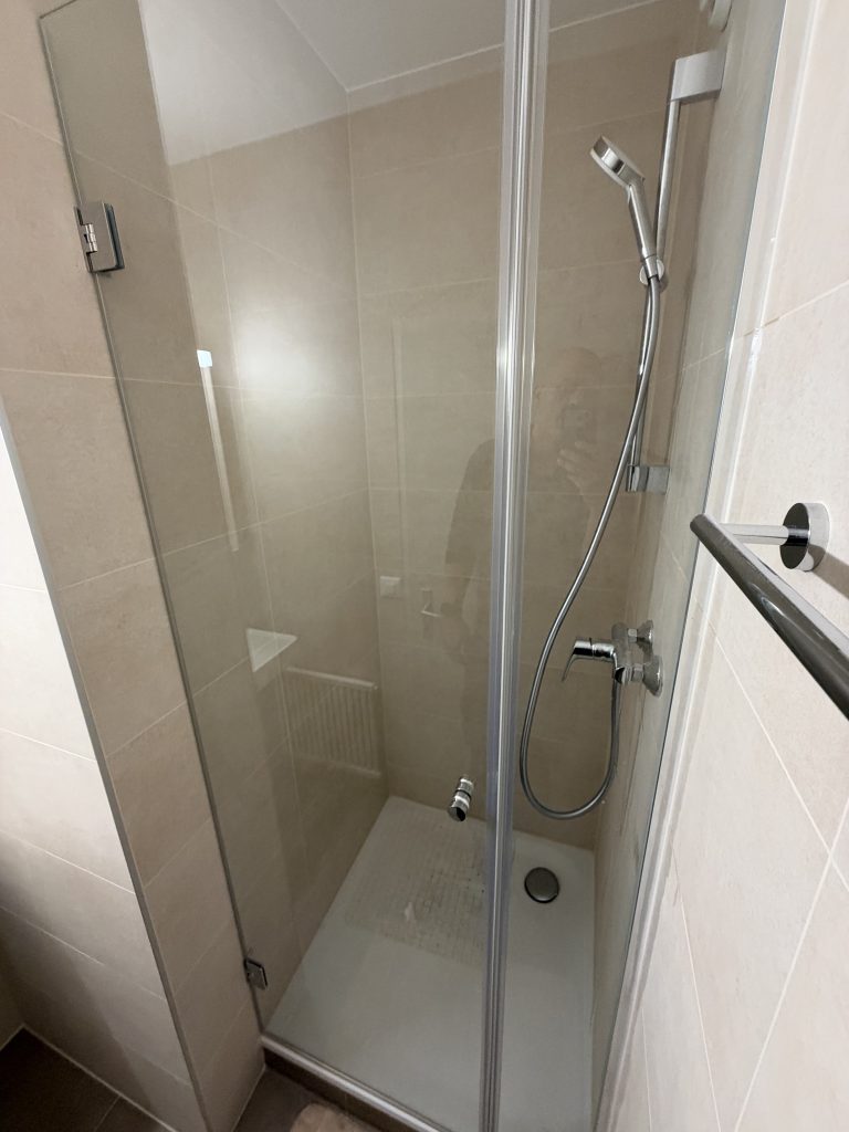 Porte de douche en verre avec charnières chromées et poignée bouton